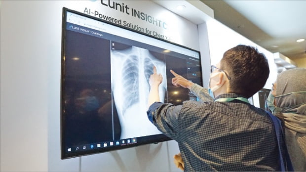 루닛 직원이 지난해 열린 ‘싱가포르 영상의학학회(SGCR WIRES)’에서 참석자에게 흉부 엑스레이 영상분석 솔루션 ‘루닛 인사이트 CXR’를 설명하고 있다.   루닛 제공 