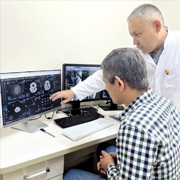 우즈베키스탄 중앙군병원 의료진이 한국 기업 JLK의 뇌경색·뇌출혈 진단 솔루션 분석 결과를 환자에게 설명하고 있다. /정보통신산업진흥원 제공 