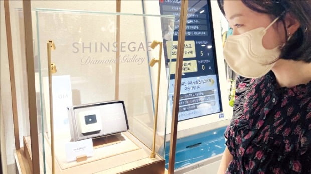 한 고객이 신세계 다이아몬드 갤러리에서 다이아몬드를 보고 있다. /신세계백화점 제공 
