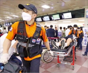 비행 중인 아시아나항공 여객기의 비상문이 열려 호흡곤란 등을 호소한 승객들이 병원으로 이송되고 있다.  /뉴스1 