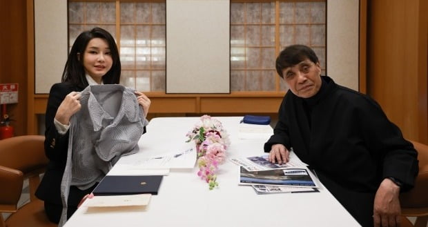 김건희 여사가 일본 방일 당시 도쿄 한 식당에서 세계적인 건축가 안도 다다오와 오찬을 하며 이세이미야케 옷을 선물받고 있다. 사진=연합뉴스