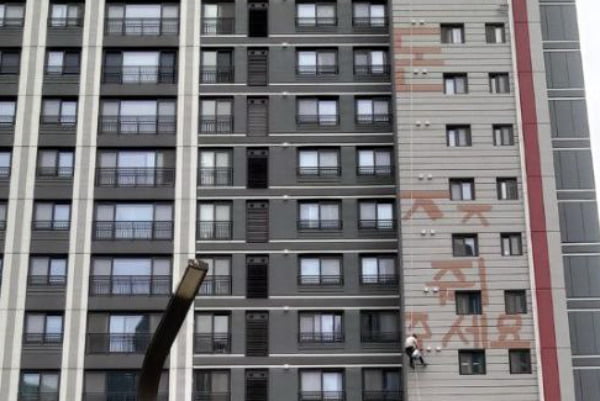 24일 오후 경기 화성시 반월동의 모 아파트에서 한 작업자가 밀린 임금을 달라며 고공 농성을 벌이고 있다. / 사진=경기도소방재난본부