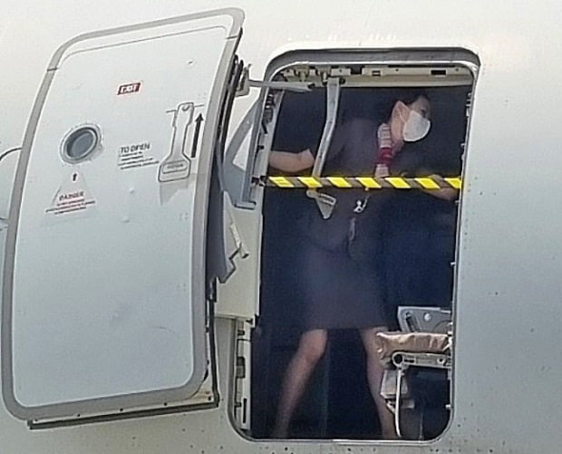 지난 26일 제주에서 출발해 대구로 향하던 아시아나항공기에 탑승한 30대 남성 A씨가 대구공항 상공에서 비상문을 강제로 개방해 승객들을 공포에 떨게 한 가운데 착륙을 앞두고 승무원이 열린 비상문을 온몸으로 막고 있는 사진이 확보됐다.  /사진=뉴스1