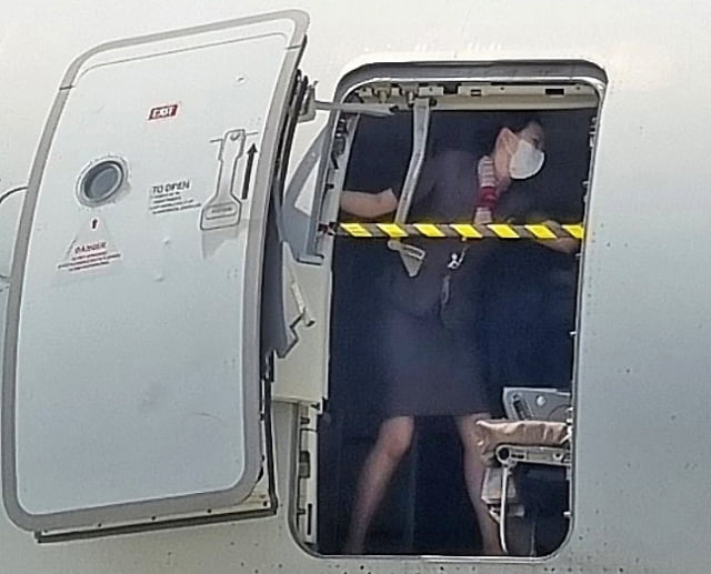 지난 26일 제주에서 출발해 대구로 향하던 아시아나항공기에 탑승한 30대 남성 A씨가 대구공항 상공에서 비상문을 강제로 개방해 승객들을 공포에 떨게 한 가운데 승무원이 비상문을 온몸으로 막고 있는 사진이 확보됐다.  / 사진=뉴스1