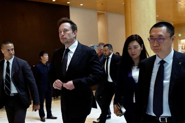 3년 만에 중국을 방문한 일론 머스크 테슬라 최고경영자(CEO)가 지난달 31일 베이징의 한 호텔을 나서고 있다. 톰 주 자동차 부문 수석 부사장(오른쪽부터)과 그레이스 타오 중국법인 부사장이 뒤를 따르고 있다. /사진=REUTERS