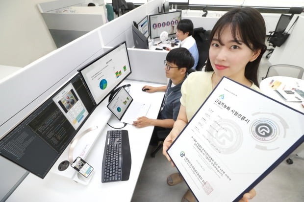 KT 직원이 ‘AI 푸드 태그’ 솔루션에 대한 한국인공지능협회 인증서를 들고 있다. KT 제공