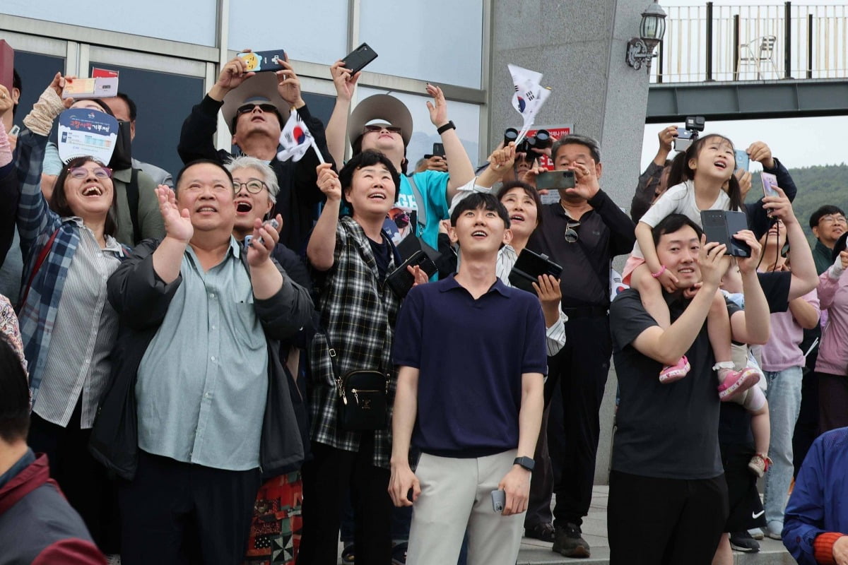 25일 전남 고흥군 나로우주센터에서 관람객들이 태극기를 들고 환호하고 있다./연합뉴스