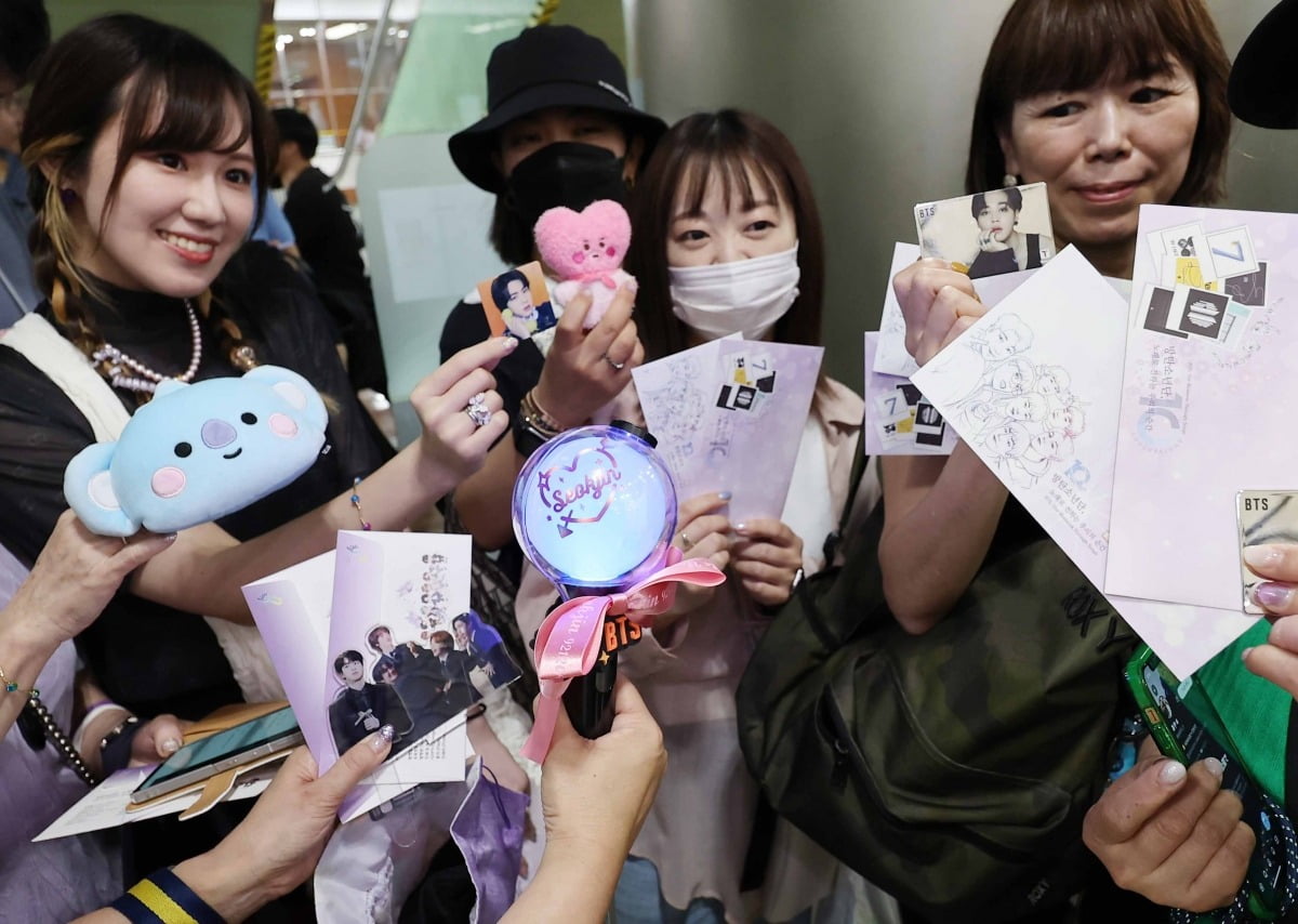 13일 서울중앙우체국에서 BTS 기념우표를 구입하기 위해 기다리고 있는 해외팬들이 BTS 굿즈를 보여주고 있다./뉴스1