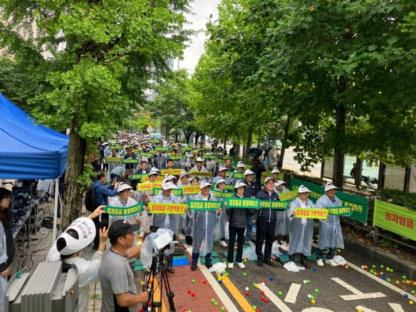 21일 서울 여의도 국회의사당 앞에서 소상공인들이 결의대회를 열고 구호를 외치고 있다.