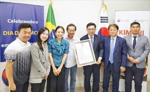 김춘진 한국농수산식품유통공사 사장(오른쪽 세 번째)이 아우렐리오 노무라 브라질 상파울루시 의원(네 번째)으로부터 ‘김치의 날’ 제정안을 전달 받고 있다. /한국농수산식품유통공사 제공 