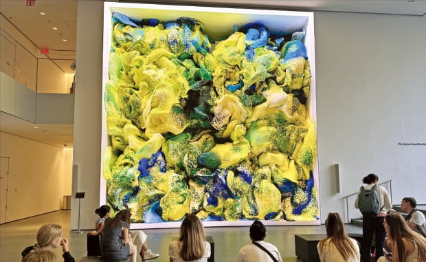 25일 미국 뉴욕 현대미술관(MoMA·모마)을 찾은 관람객들이 레픽 아나돌의 ‘비감독(Unsupervised)’(2022)을 감상하고 있다. 실시간으로 색채와 모양이 바뀌는 이 작품은 인공지능(AI)이 모마 소장품 데이터를 수집해 만들었다.  정소람 특파원 