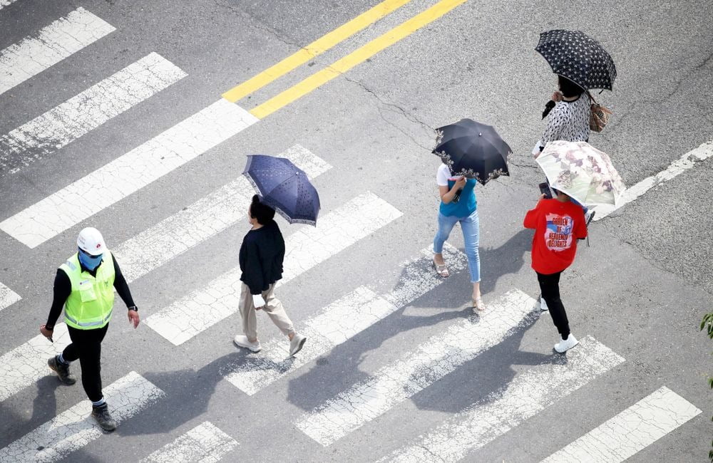광주 서구 치평동에서 시민들이 햇빛을 가리는 양산을 쓰고 걷고 있는 모습. 사진=연합뉴스