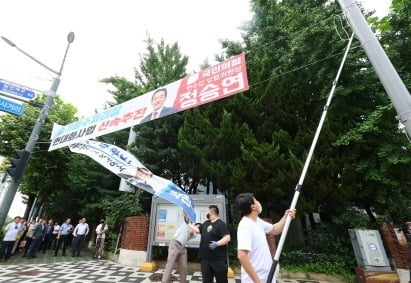 12일 오전 인천시 연수구 소금밭사거리에서 연수구청 관계자들이 시 조례 위반 정당 현수막을 강제 철거하고 있다. 사진=연합

