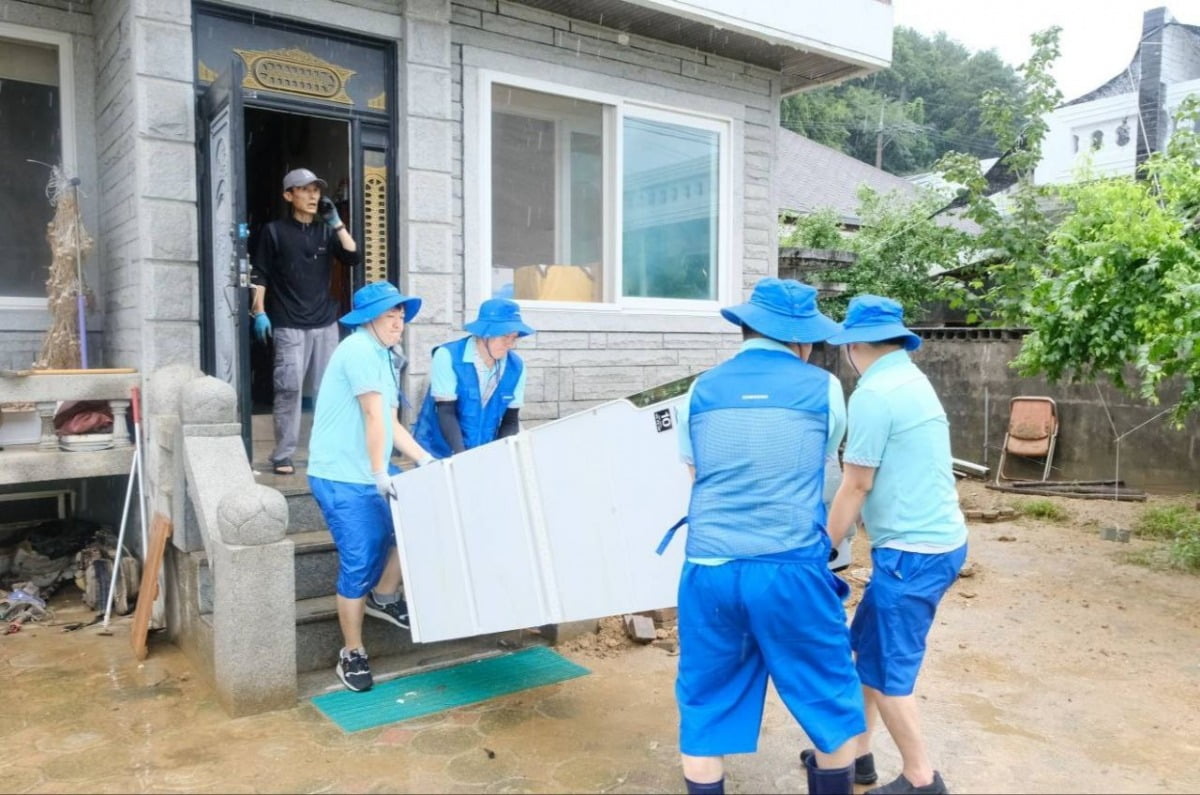 삼성전자서비스 임직원들이 침수된 냉장고를 수리하기 위해 옮기고 있다. / 사진=삼성전자서비스 제공