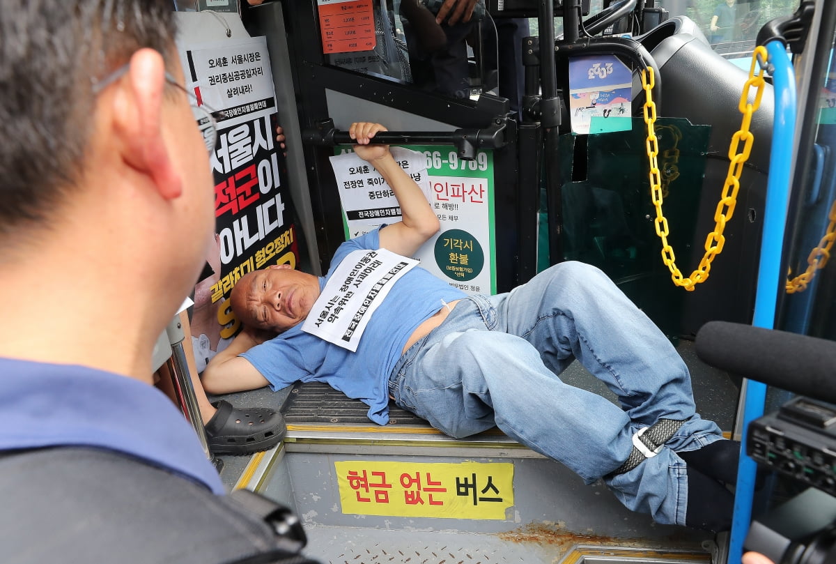 전국장애인차별철폐연대(전장연) 회원들이 17일 오후 서울 종로구 혜화동로터리 버스 정류장에서 전장연 탄압 중단을 촉구하며 '계단 버스' 탑승을 시도하고 있다. /사진=뉴스1