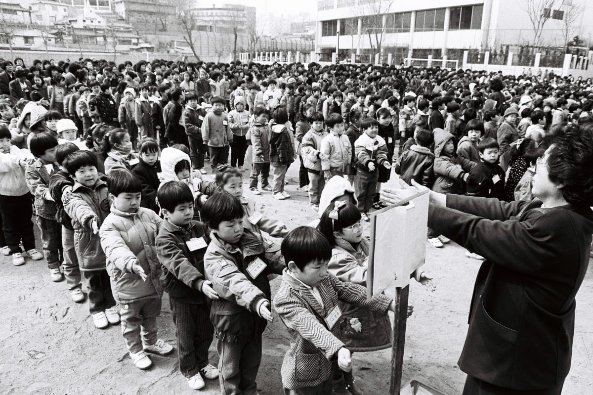 서울 미동 국민학교(초등학교)에서 신입생들이  1988년 3월 4일 교사의 지도에 따라 '앞으로 나란히'를 하고 있다. 당시 입학식 땐, 학교 운동장이 가득 찰 정도로 학생들이 많이 들어왔다./한경디지털자산