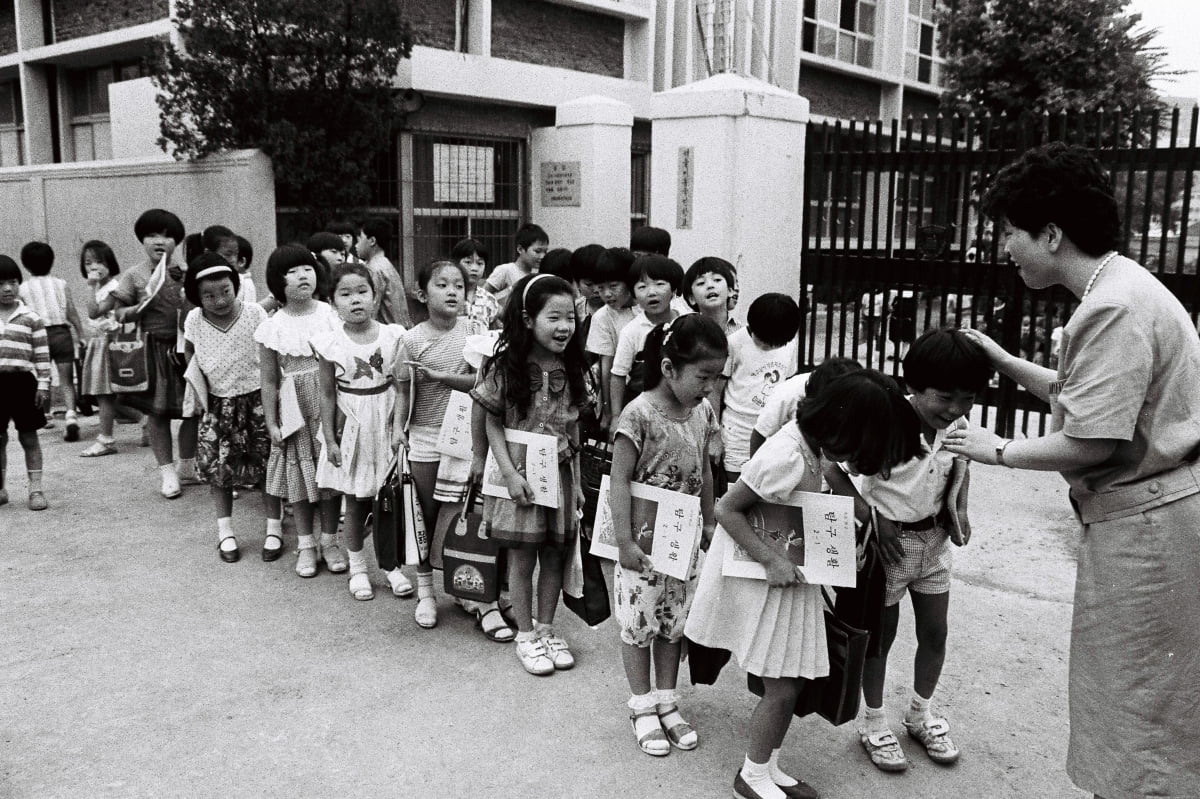 여름 방학을 맞은 어린이들이  1986년 7월 16일 서울 미동 국민학교 정문 앞에서 담임 선생님에게 인사하고 있다. /한경디지털자산