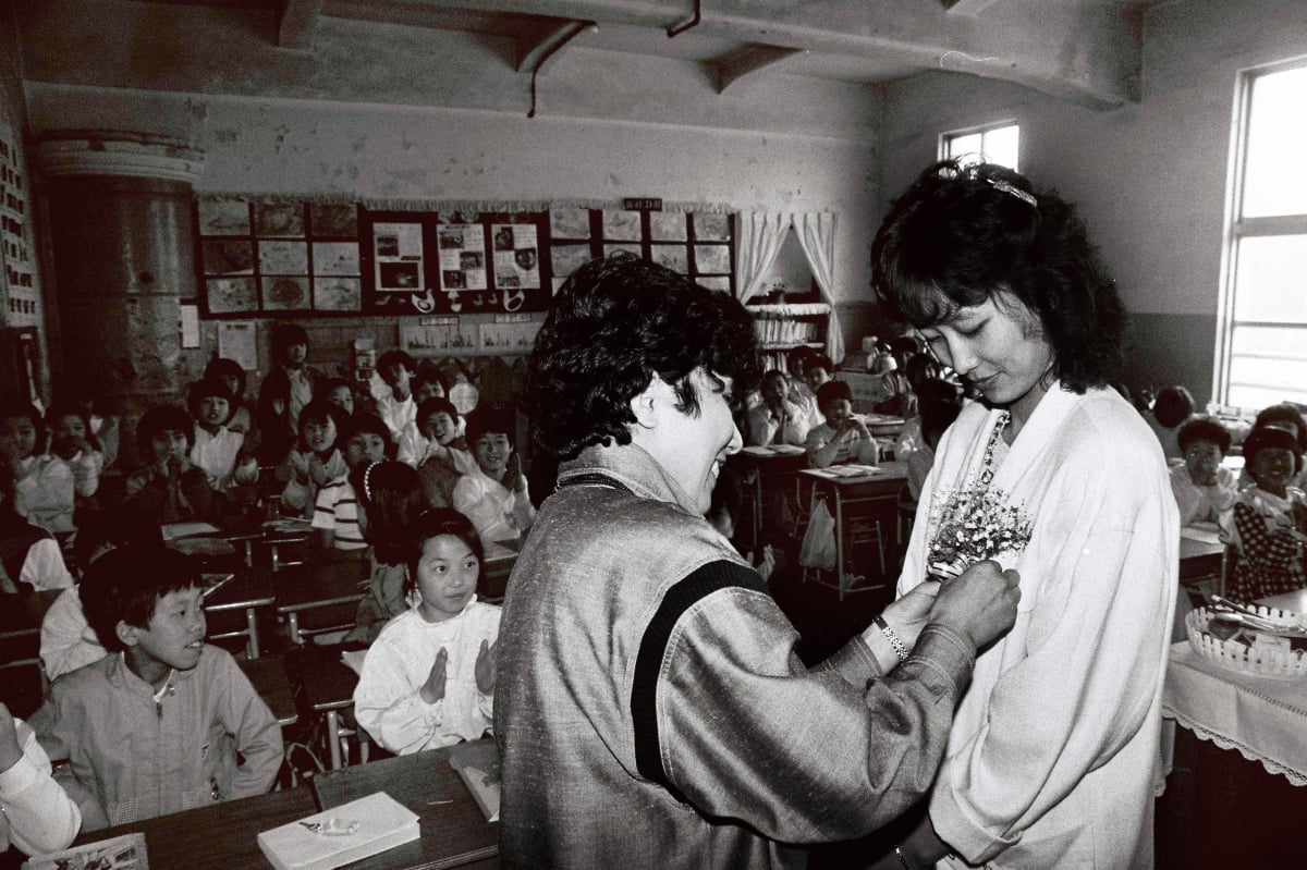 스승의 날인 1986년 5월 15일 서울의 한 국민학교에서 학부모 대표가 교사에게 꽃을 달아주고 있다. 1980~1990년대엔 스승의 날에 학부모들이 담임교사를 대신해 수업을 하곤 했다. 지금도 일부 학교에선 이 전통이 이어지고 있다./한경디지털자산