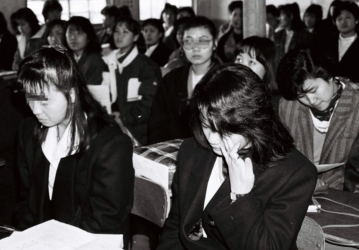 서울 용산구 한 고등학교 학생들이 졸업식이 열린 1989년 2월 14일 교실에서 눈물을 흘리고 있다. 졸업식이 열리면, 많은 여학생들이 교사, 친구들과 헤어지는 것을 아쉬워하며 울곤 했다. /한경디지털자산