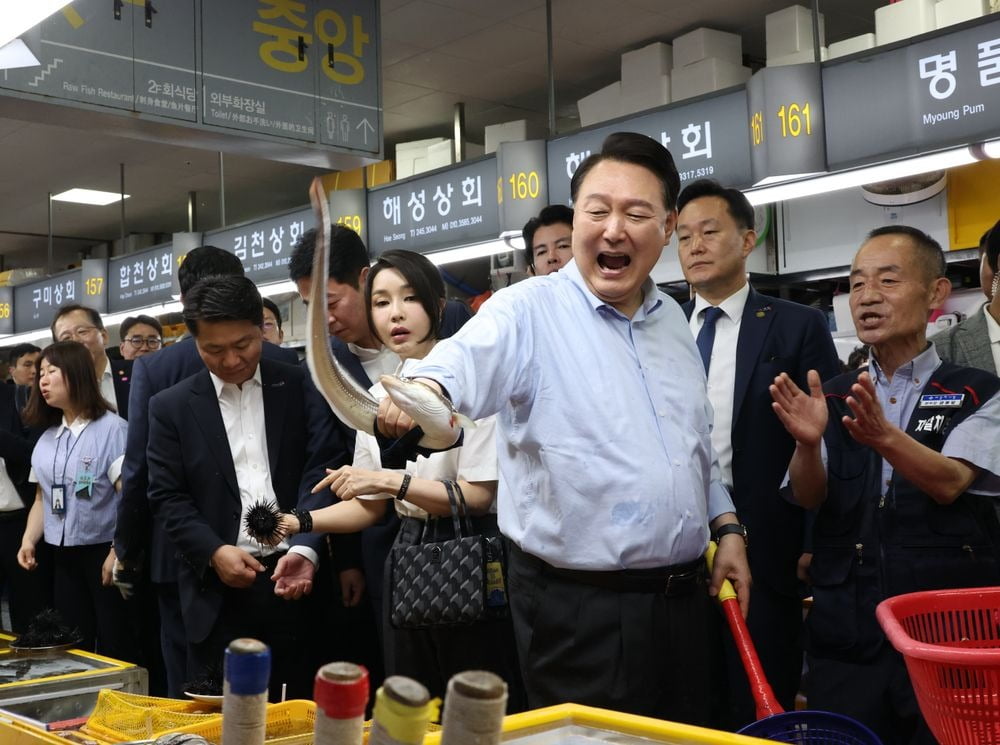 윤석열 대통령이 27일 부산 자갈치시장에서 붕장어를 직접 손으로 잡아 보며 즐거워 하고 있다. 연합뉴스