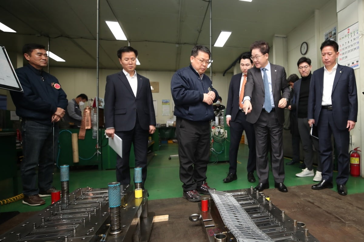 강석훈 산업은행 회장(앞줄 오른쪽 두번째)이 지난 2월 2차전지 유망 중소기업인 신흥에스이씨 오산공장을 방문해 회사 관계자로부터 제품 설명을 듣고 있다.