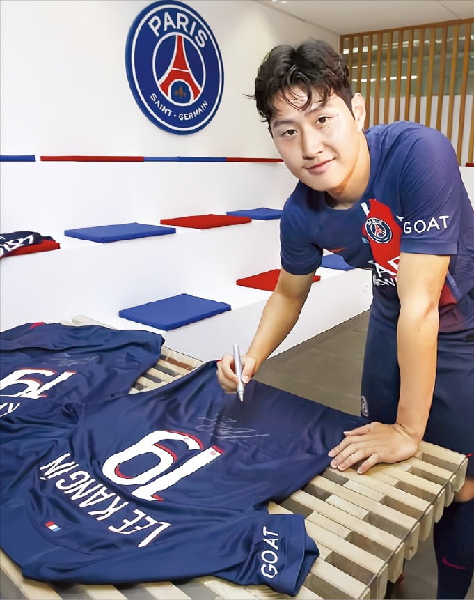 < “등번호는 19번” > 9일(한국시간) 프랑스 명문 파리 생제르맹(PSG)과 공식 계약 체결을 발표한 이강인이 자신의 등번호 19번이 적힌 새 유니폼에 사인하고 있다.  PSG 구단 홈페이지 제공 