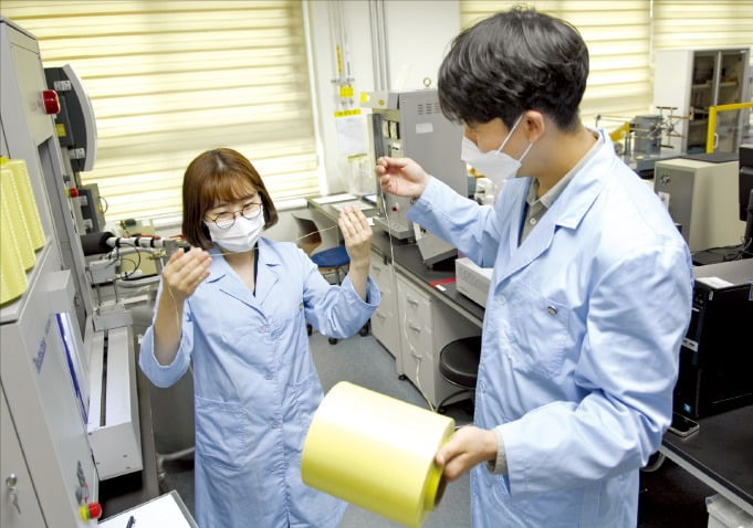 코오롱인더스트리 연구원들이 아라미드 섬유인 헤라크론 제품을 살펴보고 있다. /코오롱 제공
 