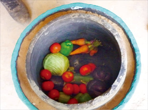 나이지리아의 한 교사가 만든 항아리 냉장고. 항아리와 항아리 사이에 넣은 젖은 모래 속 물이 증발하면서 온도를 낮춰 준다.  