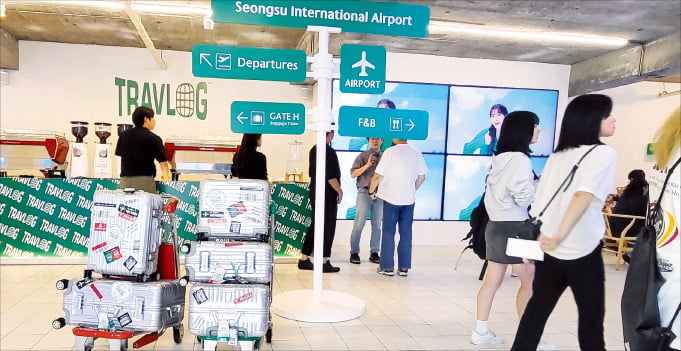 하나은행이 서울 성수동에 문을 연 팝업스토어 ‘성수국제공항’을 찾은 방문객들이 해외여행 서비스인 트래블로그를 체험하고 있다.  하나은행 제공 