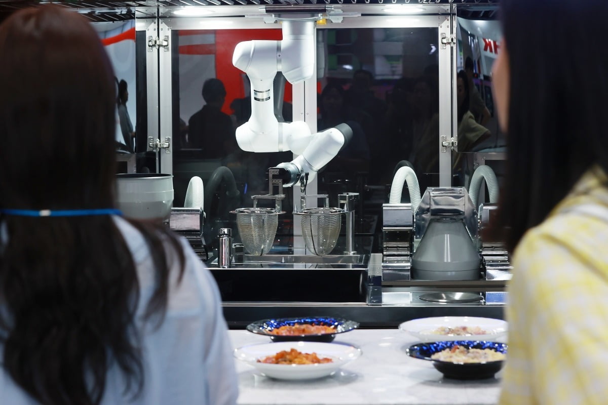 지난달 22일 서울 강남구 코엑스에서 열린 2023 우수급식·외식산업전을 찾은 참관객들이 조리로봇을 살펴보고 있다.  사진=연합뉴스