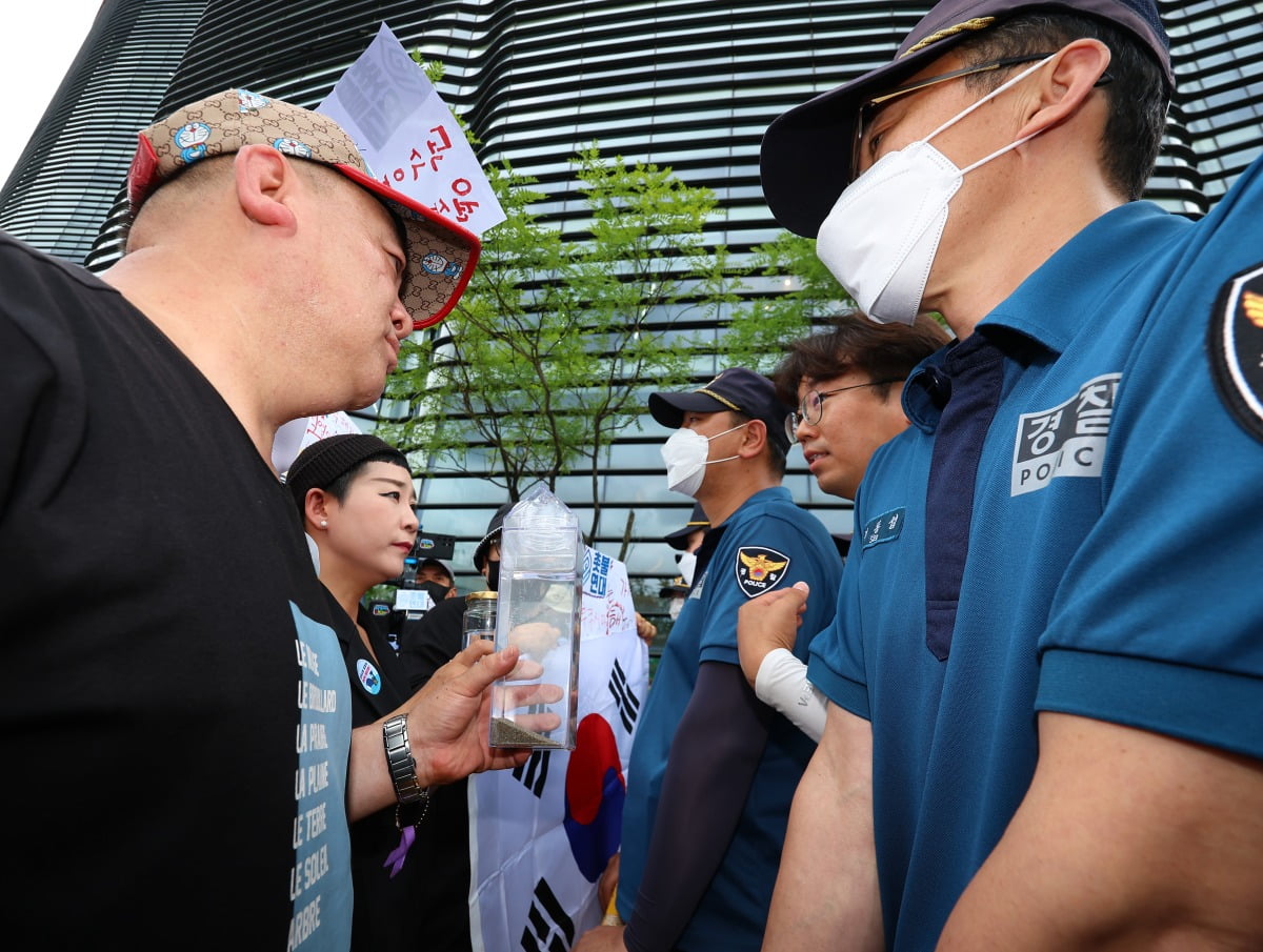 촛불연대 회원들이 지난 8일 오후 서울 종로구 일본대사관 앞에서 직접 후쿠시마 원전 인근 해상에서 떠온 바닷물을 일본대사관 측에 전달하려다 경찰에 가로막히고 있다. 가수 리아(왼쪽에서 두 번째). / 사진=연합뉴스