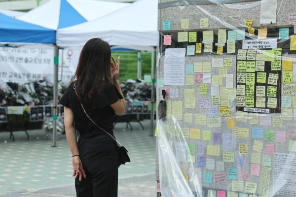  25일 서울 서초구 서이초를 찾은 한 시민이 극단선택한 교사를 추모하는 메시지를 보며 눈물을 닦고 있다. /사진=연합뉴스