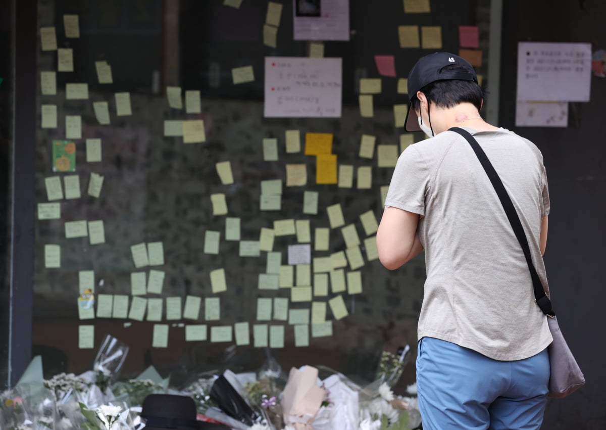 서울 관악구 신림역 인근 상가 골목에 마련된 흉기난동 사건으로 숨진 20대 남성 피해자 A씨를 위한 추모 공간에서 한 시민이 기도를 하고 있다./사진=연합뉴스