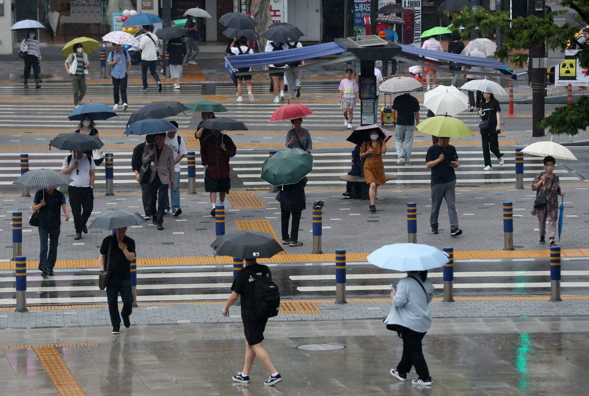 부산지역에 장맛비가 내리는 지난 7일 오후 부산역 앞에서 우산을 쓴 시민과 관광객들이 발걸음을 옮기고 있다. 사진=뉴스1