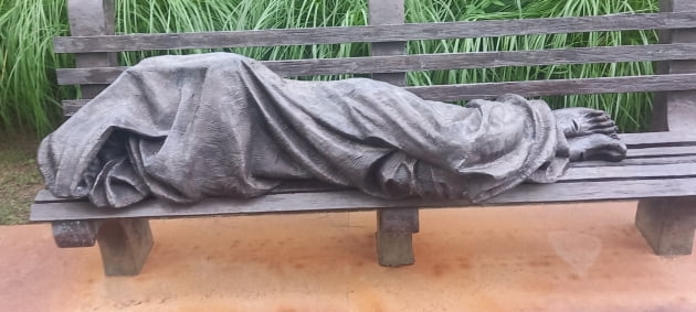 고단하게 벤치에 누워있는 노숙자 예수