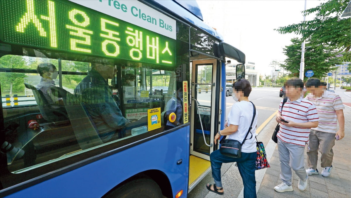 서울시가 21일 경기 화성시 동탄신도시와 김포 풍무지구에서 수도권 주민을 위한 ‘서울동행버스’ 운행을 시작했다. 이날 아침 김포시민들이 풍무동의 정류소에서 ‘서울02번’ 버스에 탑승하고 있다.  연합뉴스 