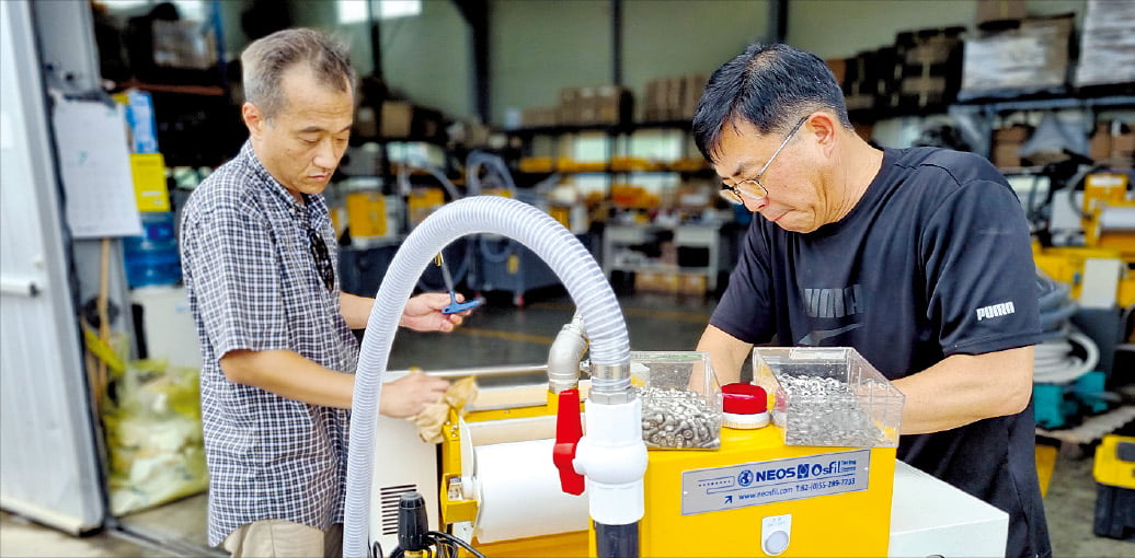 경남 창원 네오스 공장에서 근무하는 60대 엔지니어들이 국산화에 성공한 CNC 공작기계용 ‘이동형 절삭유 탱크 청소기’ 성능을 점검하고 있다.  네오스 제공 