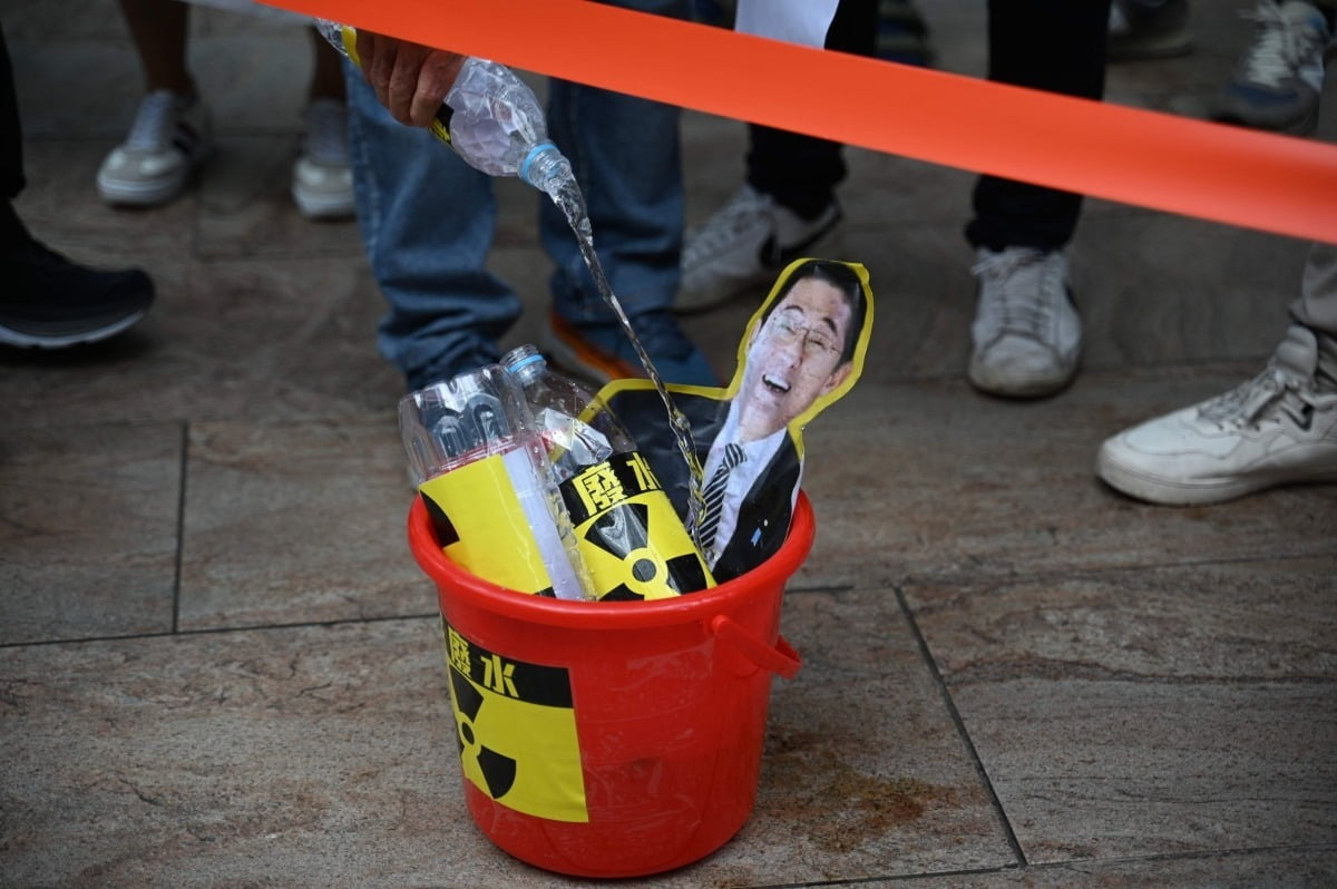 22일, 홍콩 어민이 홍콩 일본 영사관 앞 기시다 후미오 총리의 사진에 물을 붓고 있는 모습/사진=연합뉴스