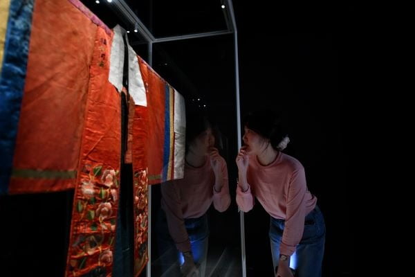 한 관람객이 '로스앤젤러스 카운티 미술관 소장 활옷'을 살펴보고 있다. 이 유물은 방탄소년단(BTS) 리더 RM의 후원을 받아 보존 복원 과정을 거쳤다. 사진: 문화재청 제공