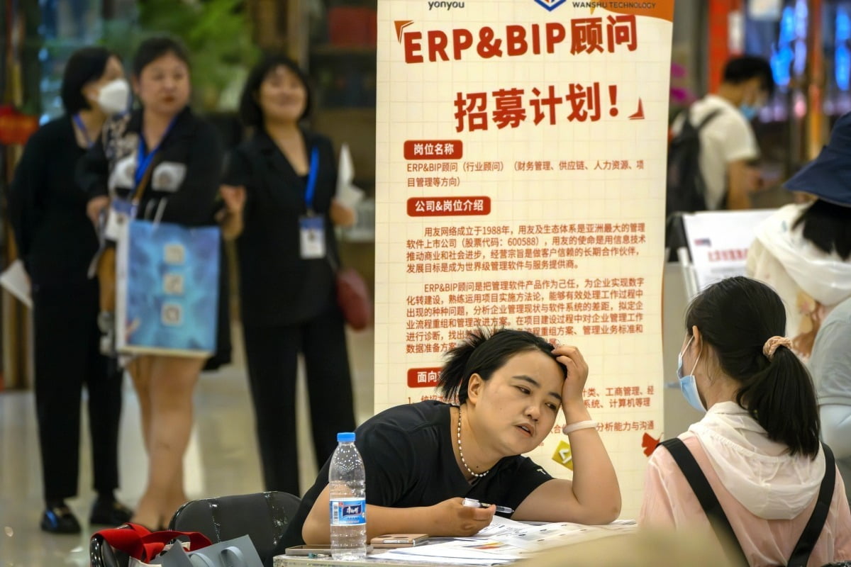 지난 6월 베이징 한 쇼핑센터에서 열린 취업 박람회 부스에서 한 채용 담당자가 지원자와 이야기를 나누고 있다. /AP