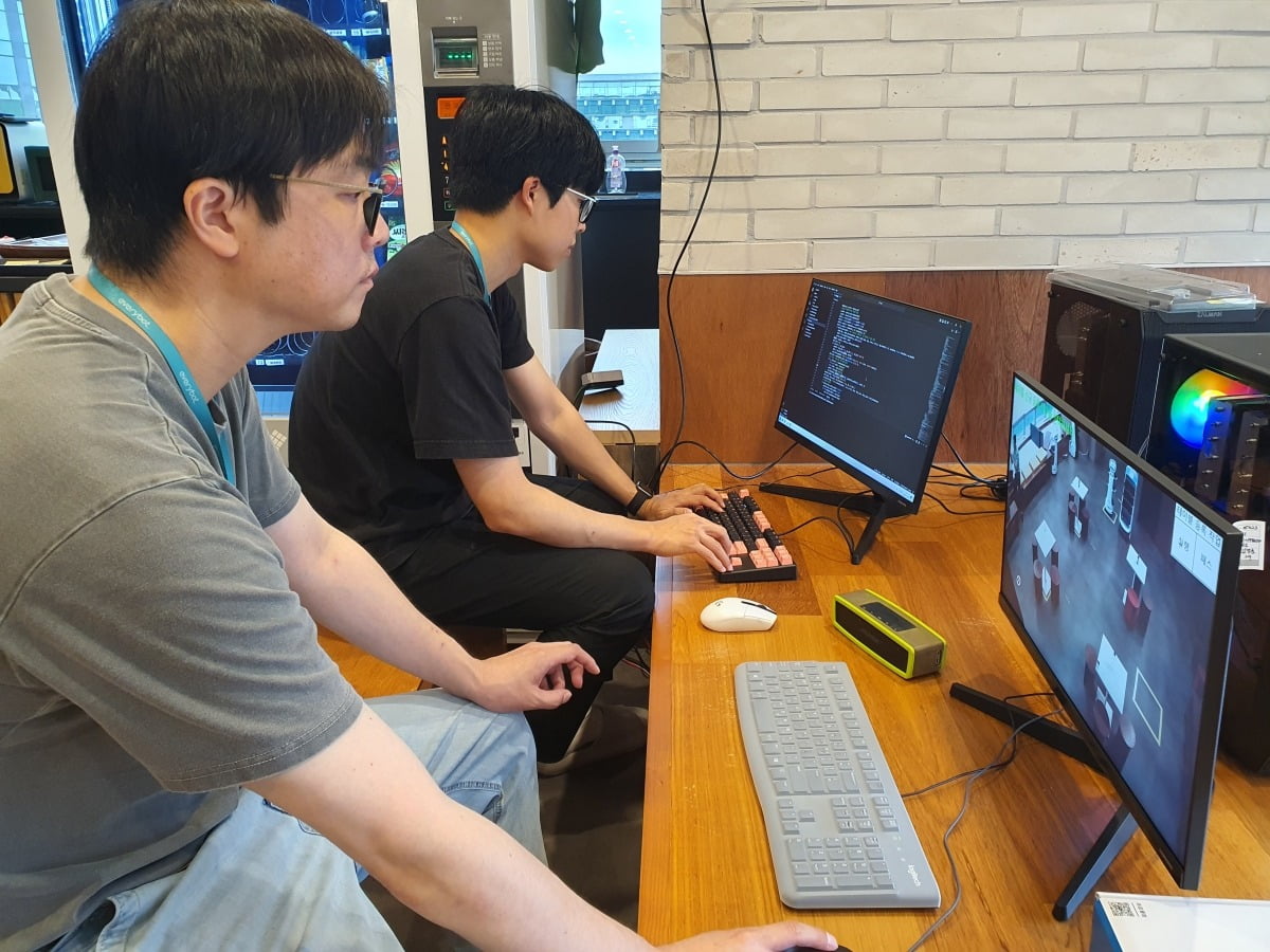 김경훈 AI 융합기술연구소 차장(오른쪽)과 라이언 대리가 서빙 로봇 호출 실험을 하고 있다.  윤현주 기자