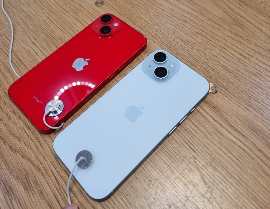 광택이 느껴지는 아이폰 14(왼쪽)과 무광으로 처리된 아이폰 15(오른쪽)