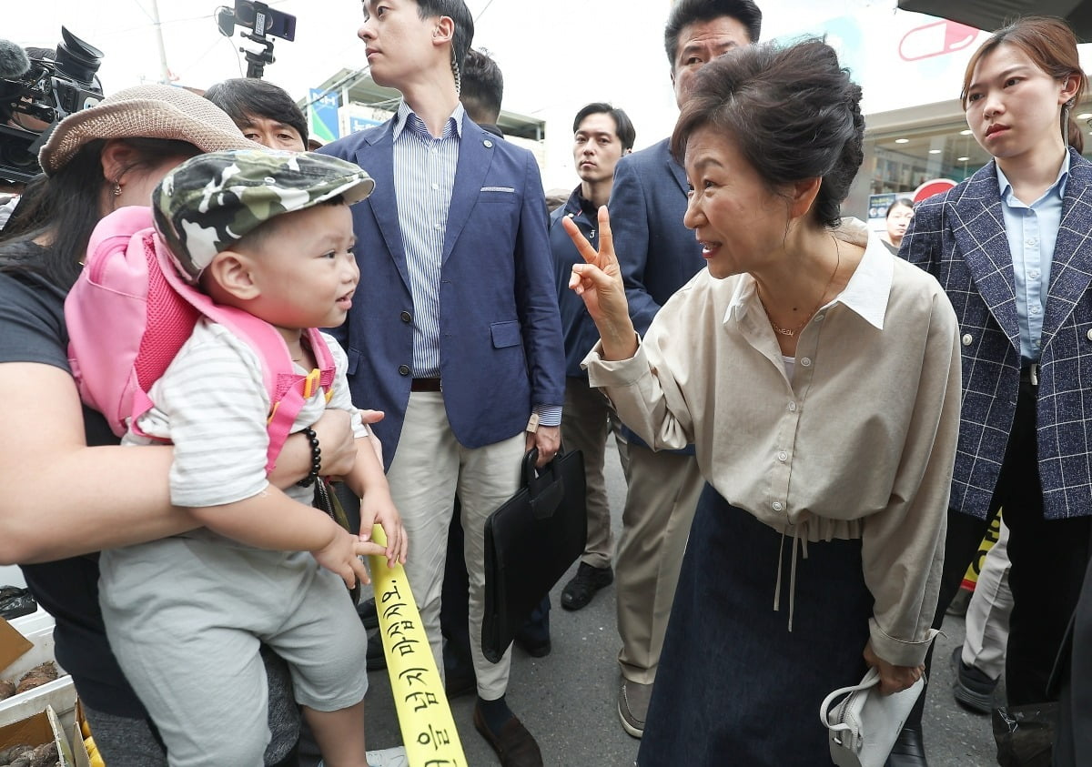 박근혜 전 대통령이 25일 대구 달성군 현풍시장에서 엄마와 함께 시장에 나온 아기와 인사 나누고 있다. 뉴스1