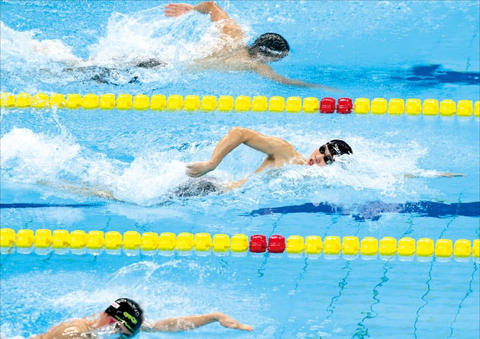 황선우(가운데)가 27일 중국 항저우 올림픽 스포츠센터 수영장에서 열린 ‘2022 항저우 아시안게임’ 남자 자유형 200m 예선에서 역영하고 있다. 황선우는 예선 1위로 결승에 진출했다. /뉴스1 
