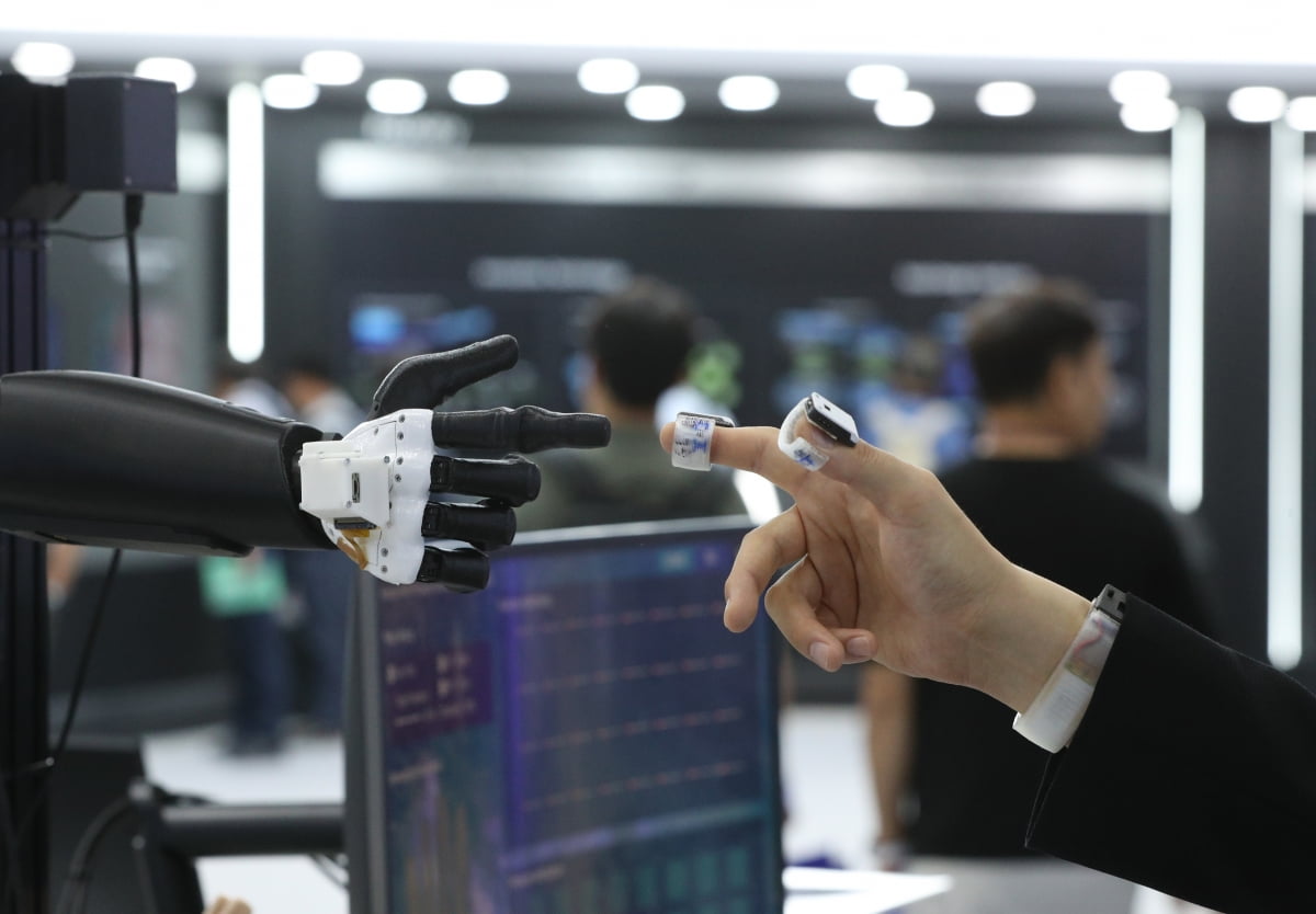  '나노코리아 2023'에서 관람객들이 모션 컨트롤러를 사용해 사람의 손동작을 따라할 수 있는 휴머노이드 로봇 암을 살펴보고 있다./사진=뉴스1