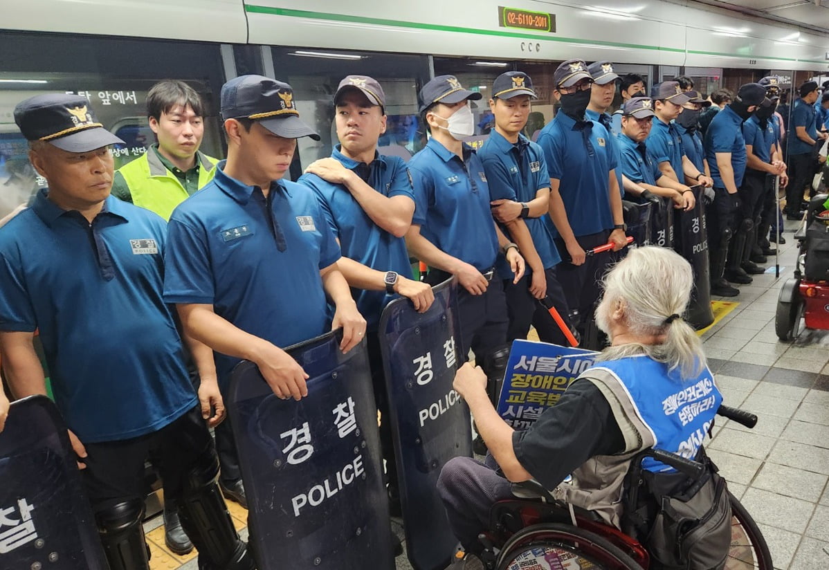 전국장애인차별철폐연대 소속 회원들이 2호선 서울시청역 승강장에서 지하철 탑승을 시도하던 중 경찰과 충돌하고 있다./사진=뉴스1