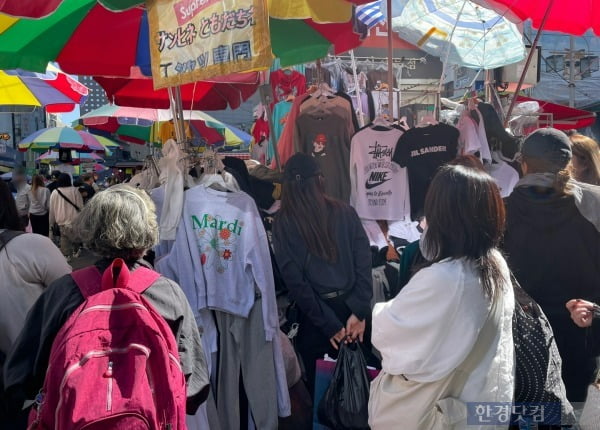 명품과 고가의 티셔츠를 빼닮은 '위조품 셔츠'를 둘러보는 시민들과 외국인 관광객들. /사진=김세린 기자