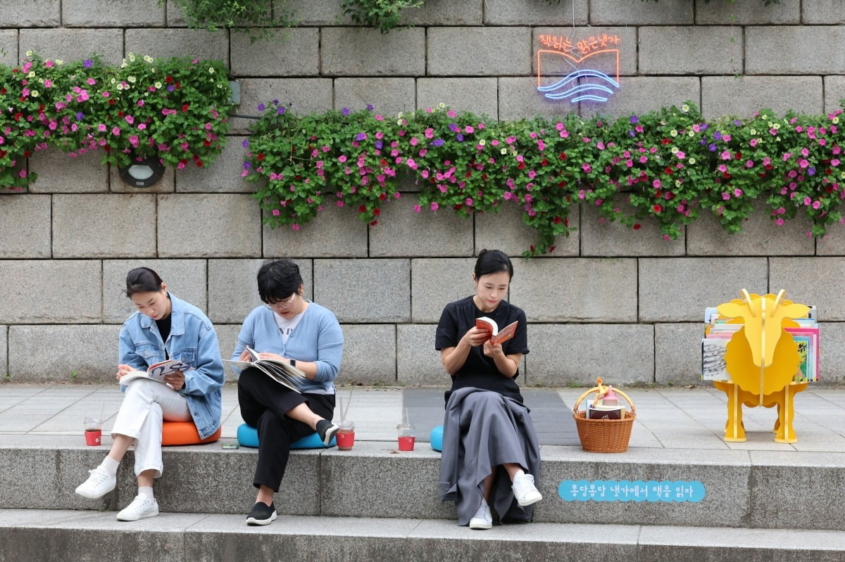 13일 서울 청계천에 마련된 책 읽는 야외도서관에서 시민들이 책을 읽으며 여유를 즐기고 있다.사진=최혁 기자