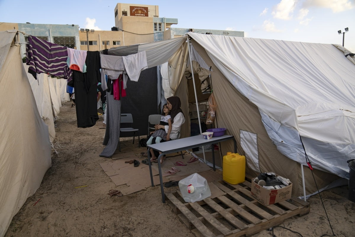 이스라엘-하마스 분쟁으로 난민이 된 팔레스타인인들이 19일(현지시간) 유엔개발계획(UNDP)가 제공한 인근 칸 유니스 난민 캠프에 앉아있다. AP