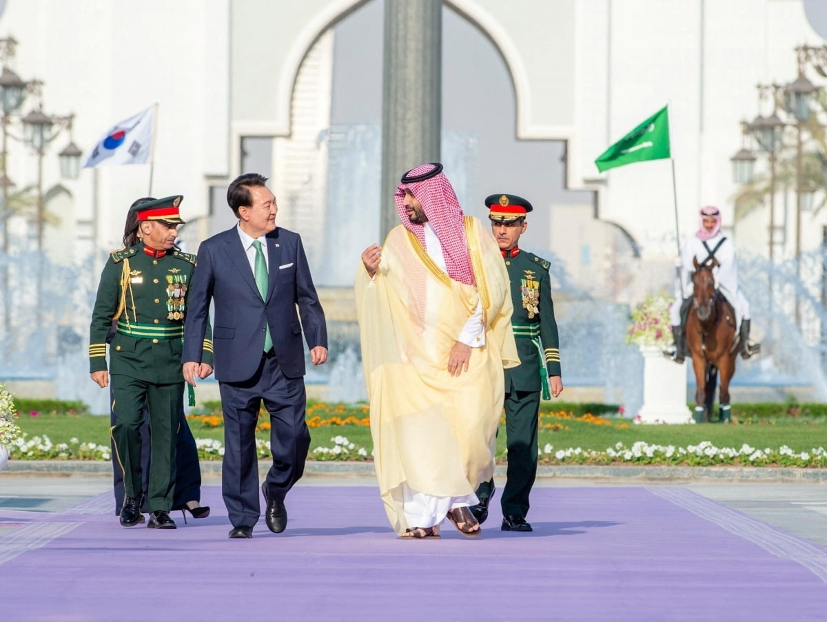 윤석열 대통령(왼쪽)이 지난 22일(현지시간) 사우디아라비아 리야드 알 야마마 궁에서 무함마드 빈 살만 사우디 왕세자와 대화하며 걷고 있다. 로이터